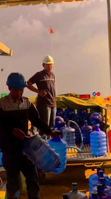 Petugas menangani galon air minum di area kerja